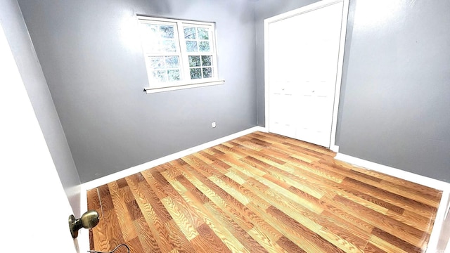 spare room featuring light wood-type flooring and baseboards