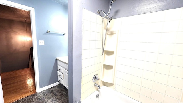 bathroom with shower / bath combination, baseboards, a textured ceiling, and vanity