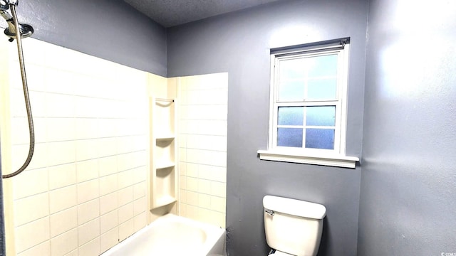 bathroom featuring bathtub / shower combination and toilet