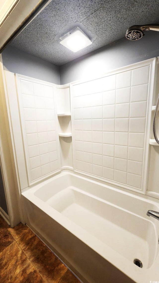 bathroom with shower / bathing tub combination and a textured ceiling