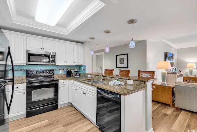 kitchen featuring black appliances, kitchen peninsula, sink, hanging light fixtures, and white cabinetry