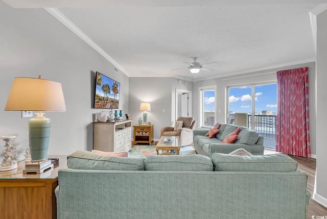 living room featuring crown molding, hardwood / wood-style floors, ceiling fan, and a textured ceiling