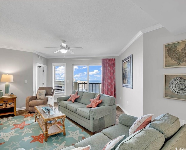 living room featuring crown molding, ceiling fan, wood-type flooring, and a textured ceiling