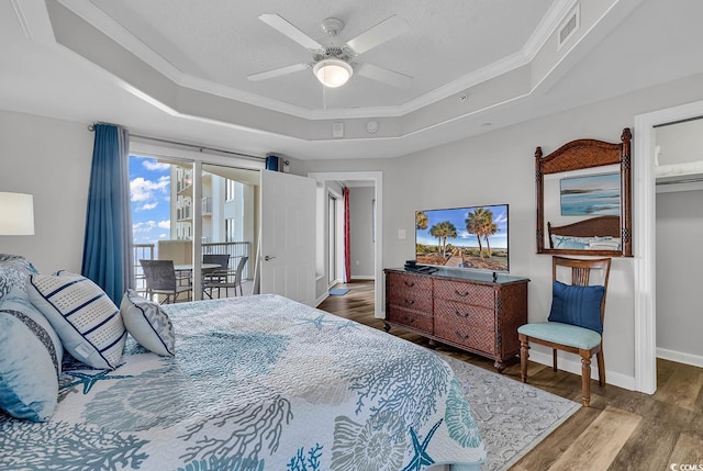 bedroom featuring a tray ceiling, ceiling fan, hardwood / wood-style floors, and crown molding