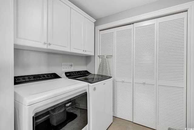 washroom with separate washer and dryer, light tile patterned flooring, and cabinets