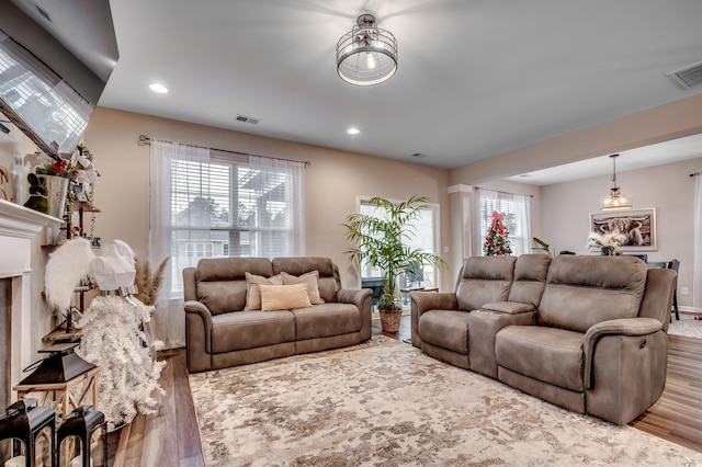 living room featuring hardwood / wood-style floors, decorative columns, and plenty of natural light