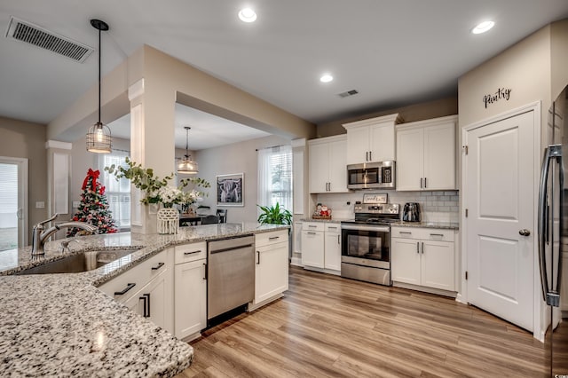 5433 Merrywind Ct, Myrtle Beach, SC 29579 - kitchen featuring appliances with stainless steel finishes, white cabinets, pendant lighting, tasteful backsplash, and recessed lighting