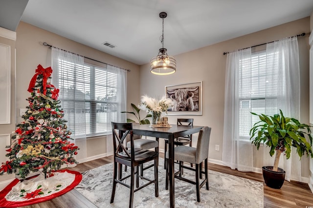 dining area with a notable chandelier, wood-type flooring, and a wealth of natural light