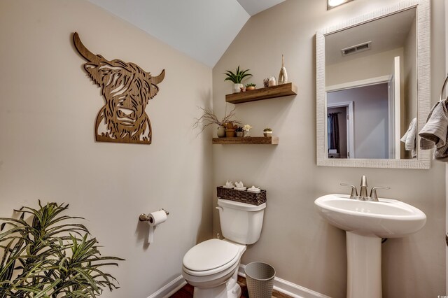 bathroom featuring toilet and vaulted ceiling