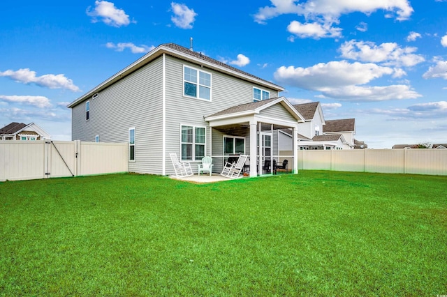 back of house with a lawn and a patio