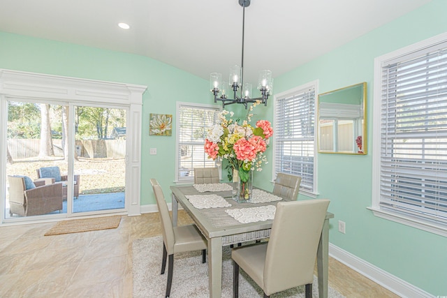 dining room with tile patterned floors, vaulted ceiling, a wealth of natural light, and a notable chandelier