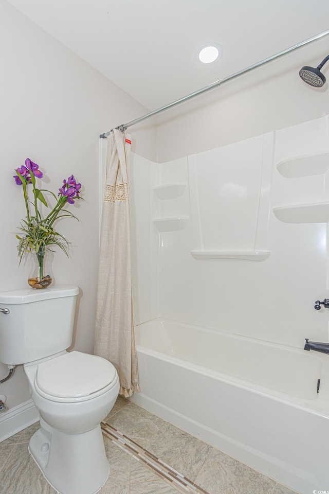 bathroom featuring shower / bath combo with shower curtain, tile patterned flooring, and toilet