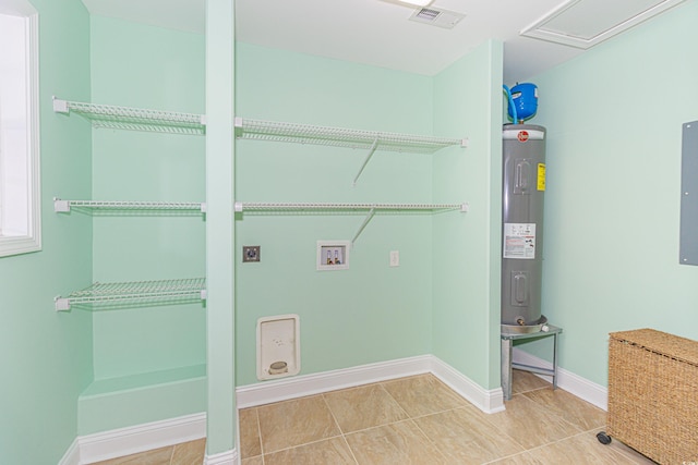 laundry area with hookup for an electric dryer, washer hookup, electric water heater, and tile patterned floors