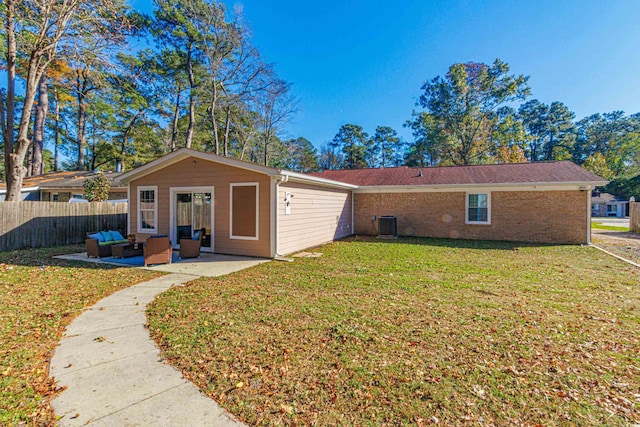 rear view of house with a yard and an outdoor living space