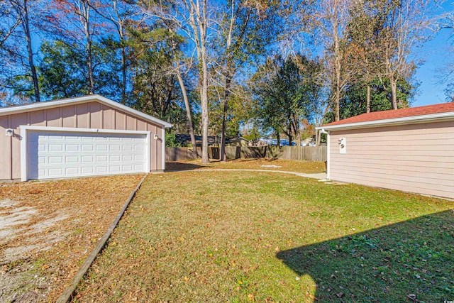 view of yard featuring a garage and an outbuilding