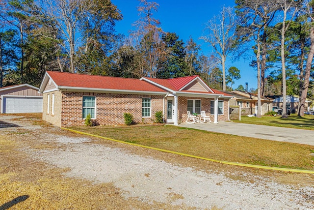 ranch-style home featuring an outbuilding, a front yard, and a garage