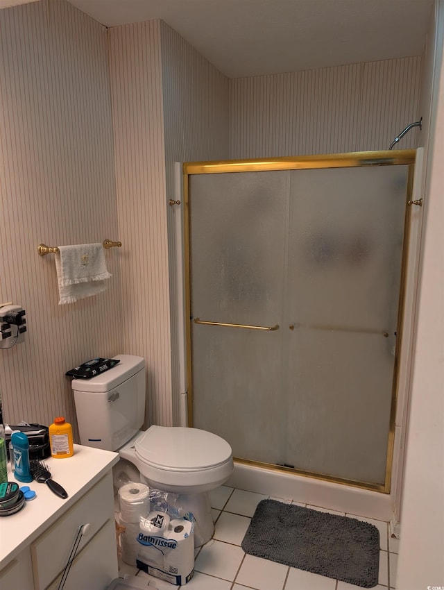 bathroom with tile patterned flooring, vanity, toilet, and walk in shower