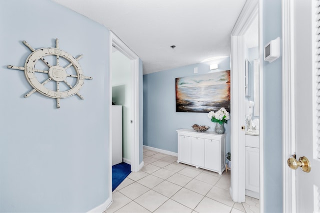 corridor with light tile patterned flooring and a textured ceiling