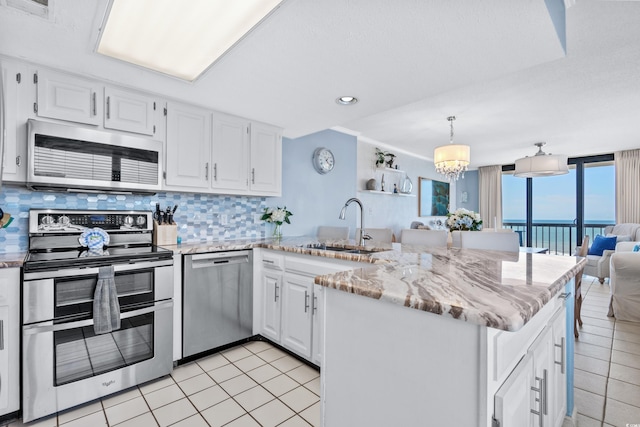 kitchen with white cabinetry, a water view, kitchen peninsula, and stainless steel appliances