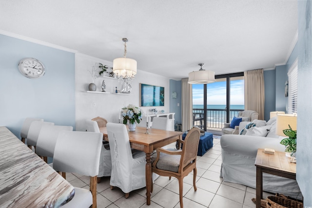 dining space featuring floor to ceiling windows, a water view, crown molding, light tile patterned flooring, and a chandelier