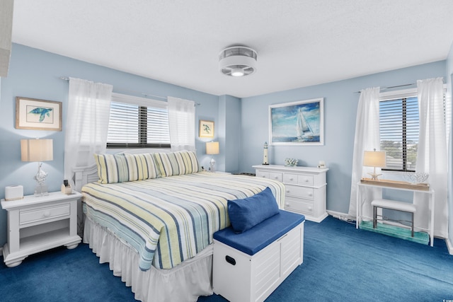 bedroom featuring dark carpet and multiple windows