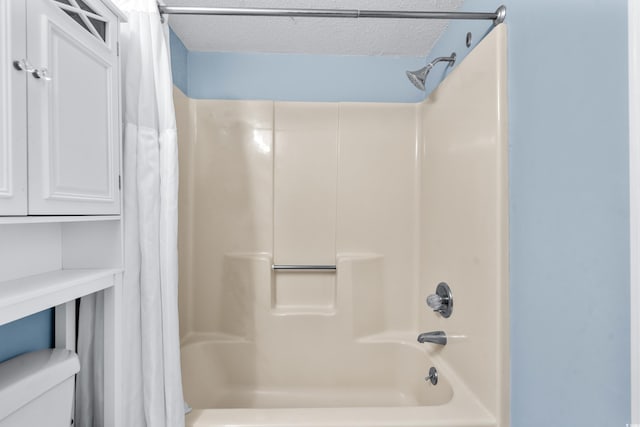 bathroom featuring shower / bath combo with shower curtain, a textured ceiling, and toilet