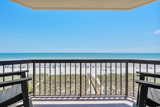 balcony with a beach view and a water view