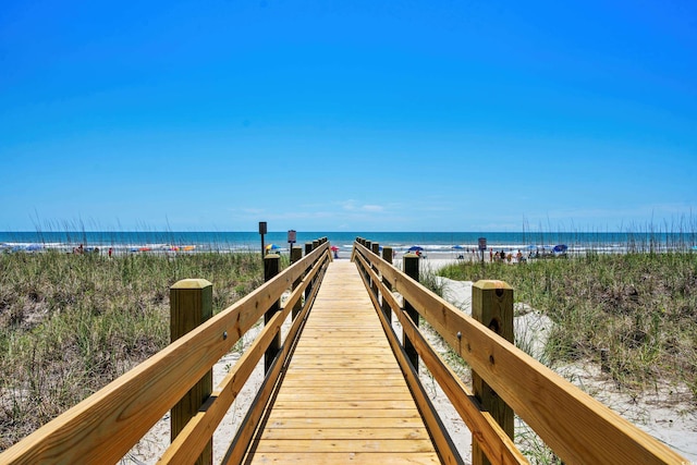 view of dock with a water view and a view of the beach