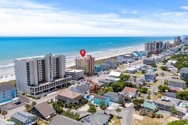 drone / aerial view featuring a water view and a view of the beach