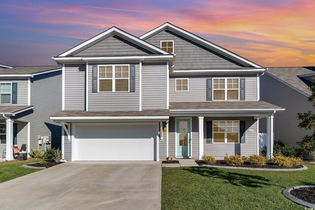 view of front of house featuring a garage and a lawn