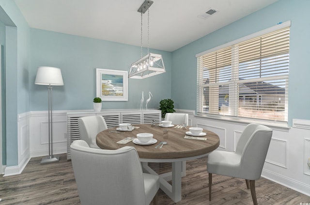 dining room featuring wood-type flooring and a healthy amount of sunlight