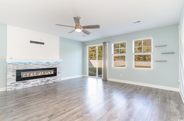 unfurnished living room with hardwood / wood-style flooring, ceiling fan, and a fireplace