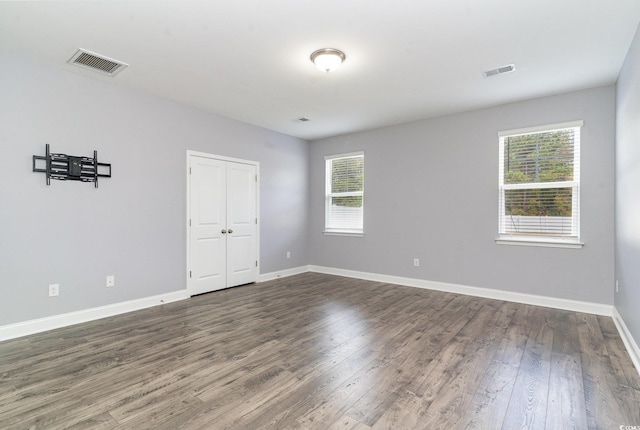 unfurnished room featuring a wealth of natural light and dark hardwood / wood-style flooring