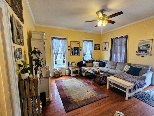 living room with dark wood-type flooring, ornamental molding, and ceiling fan