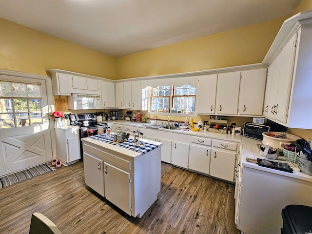 kitchen with hardwood / wood-style flooring, white cabinetry, a center island, and stainless steel electric range