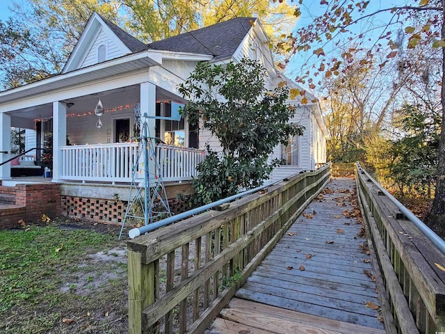 view of side of home featuring covered porch