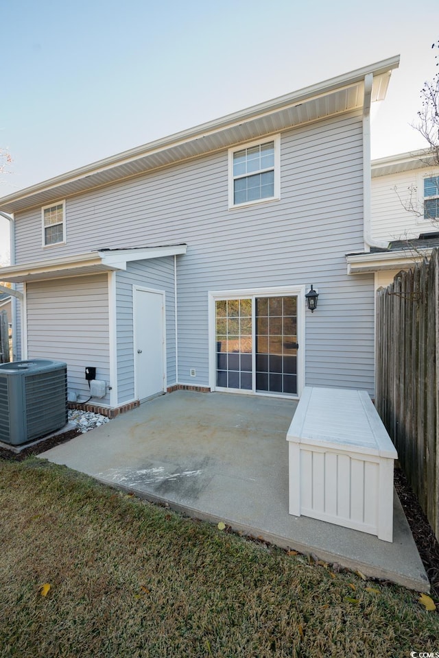 back of property with central air condition unit and a patio