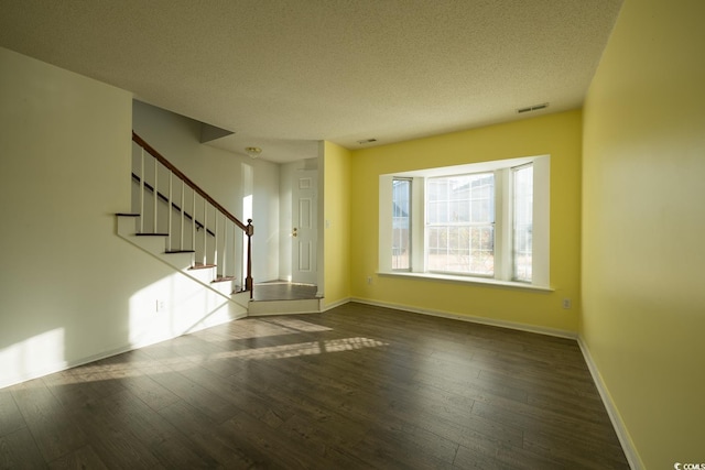 unfurnished room featuring hardwood / wood-style floors, ceiling fan, and a textured ceiling