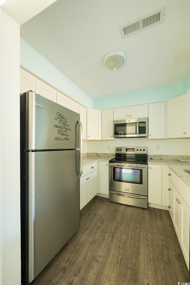 kitchen with white cabinetry, light stone countertops, dark hardwood / wood-style floors, a textured ceiling, and appliances with stainless steel finishes