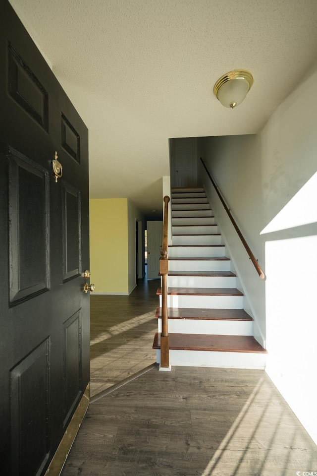 stairway featuring hardwood / wood-style floors and a textured ceiling