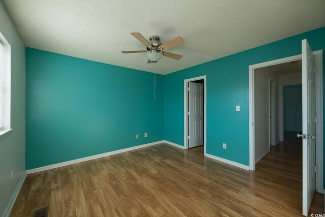 unfurnished bedroom with hardwood / wood-style floors, a textured ceiling, and ceiling fan