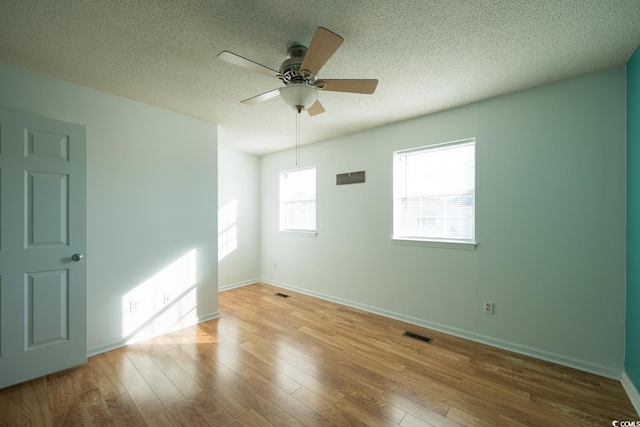 empty room featuring ceiling fan, a textured ceiling, and light wood-type flooring