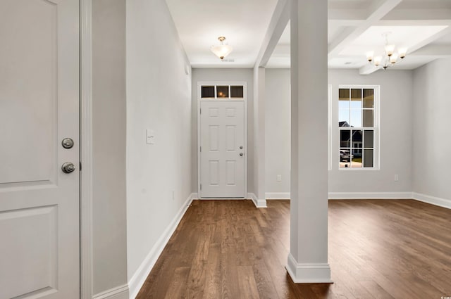 foyer entrance featuring beam ceiling, dark hardwood / wood-style flooring, a chandelier, and coffered ceiling