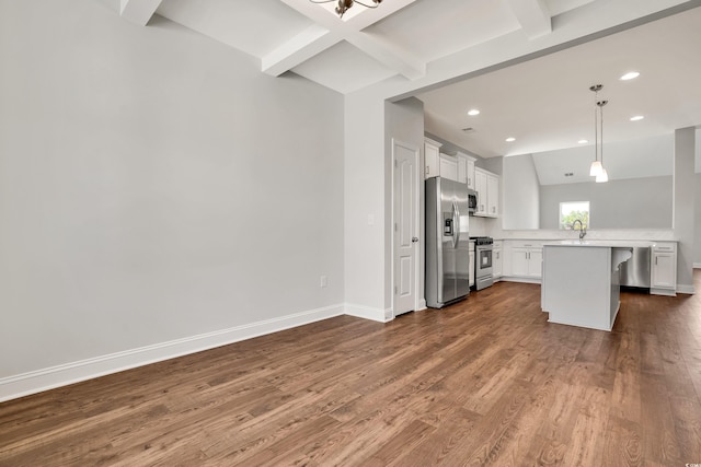 kitchen with dark wood-type flooring, stainless steel appliances, kitchen peninsula, decorative light fixtures, and white cabinets