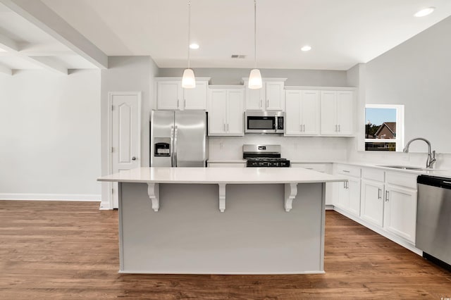 kitchen featuring hanging light fixtures, sink, appliances with stainless steel finishes, and light hardwood / wood-style flooring