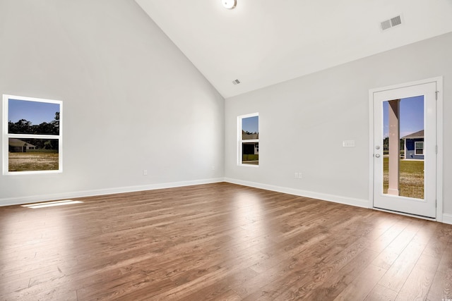 empty room featuring high vaulted ceiling and hardwood / wood-style flooring