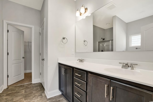 bathroom with vanity and a shower with door