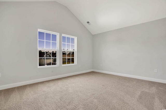 spare room with carpet flooring and high vaulted ceiling