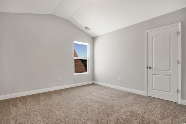 carpeted spare room featuring lofted ceiling