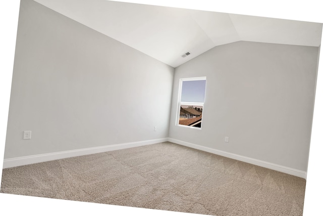 empty room with carpet flooring and vaulted ceiling